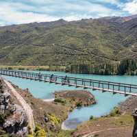 Cyclists riding across the Hugo Swingbridge on the Lake Dunstan Trail. | Geoff Marks