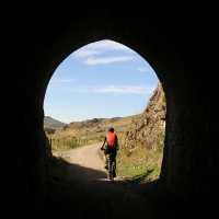Cycling through a historic railway tunnel on the Otago Rail Trail